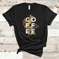 The design on this T-shirt features a beautiful coffee plant line art overlapping with the word COFFEE.